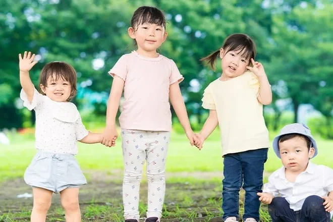 公園で手をつなぐ4人の子どもたち