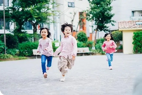広場を元気に走る3人の子どもたち