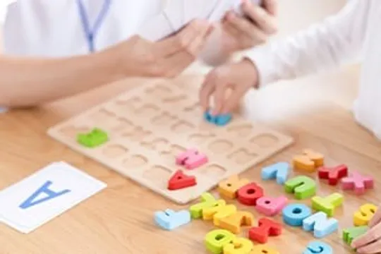 アルファベットのパズルで遊ぶ子どもの手元