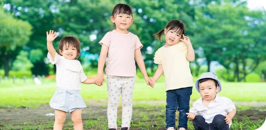 公園で手をつなぐ4人の子どもたち