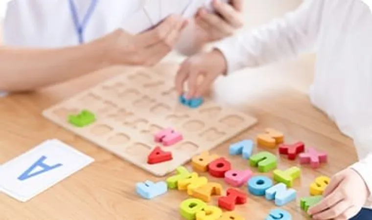 アルファベットのパズルで遊ぶ子どもの手元
