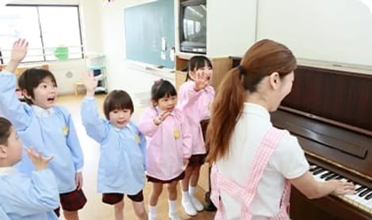 先生のピアノに合わせて園児が手を挙げる様子