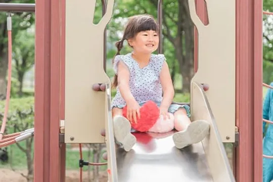 滑り台の上で笑顔の女の子