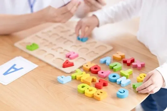 アルファベットの木製パズルで遊ぶ手元